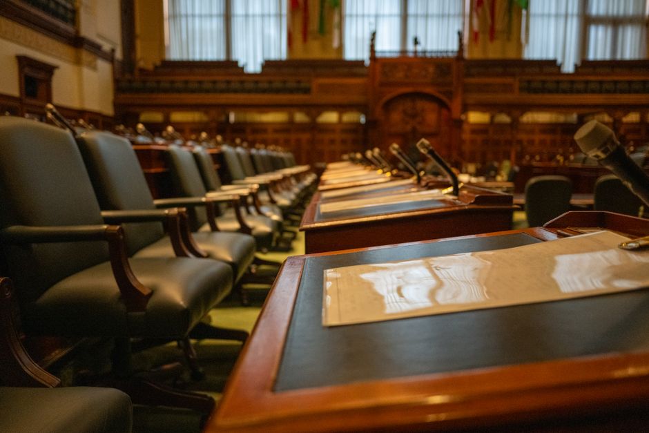Câmara Municipal SP. — A detailed view of an empty legislative chamber with rows of desks and microphones, evoking