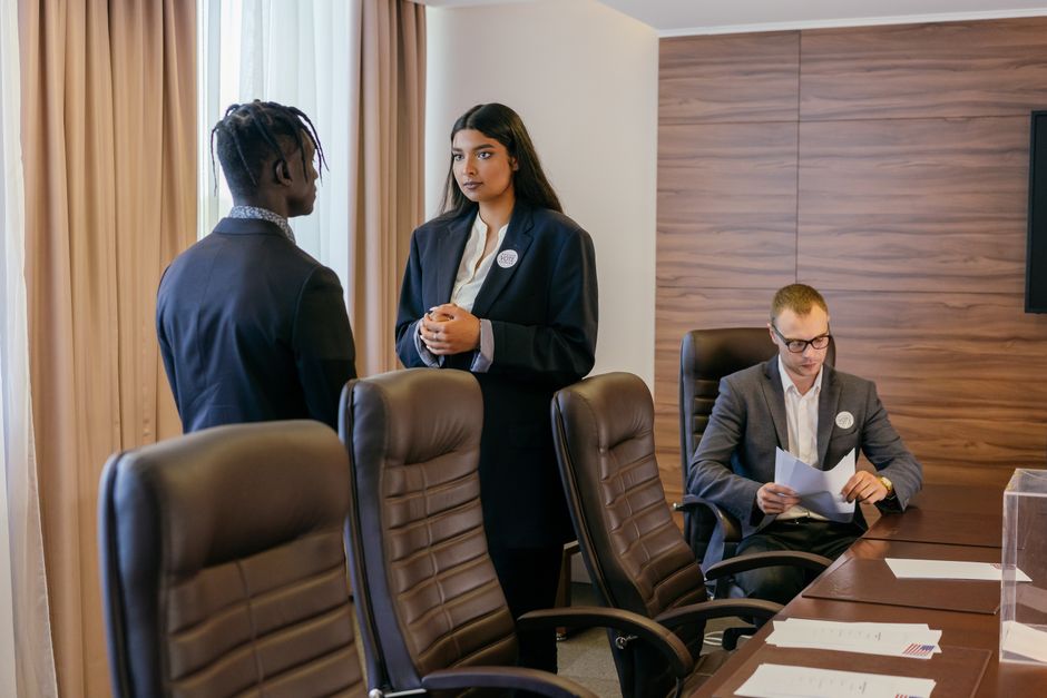Câmara Municipal SP. — Three professionals discussing business strategy in a modern conference room.